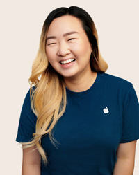 Apple Retail employee with hair pulled back, looking at the camera.