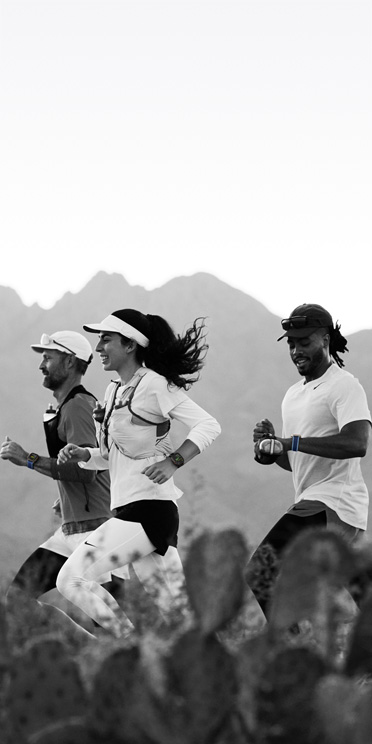 Tri osobe koje trče po pustinjskoj stazi prate svoj trening na Apple Watchu Ultra 3