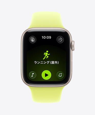 スターライトアルミニウムケースのApple Watch SE 3。屋外ランニングのワークアウトが開いていて、画面の下部にApple Musicの再生コントロールが表示されている。ネオンイエローのスポーツバンドが付いている