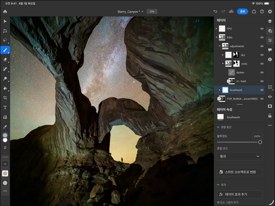 가로 방향으로 놓인 스페이스 블랙 색상 iPad Pro의 앞면 외관. 둥근 형태의 모서리와 블랙 디스플레이 베젤이 보입니다. 화면에는 협곡과 별이 가득한 밤하늘을 촬영한 사진을 편집하는 모습이 보이며, 화면의 오른쪽에는 브러시 작업, 조정 등 다양한 레이어, 도구, 효과가 표시되어 있습니다.