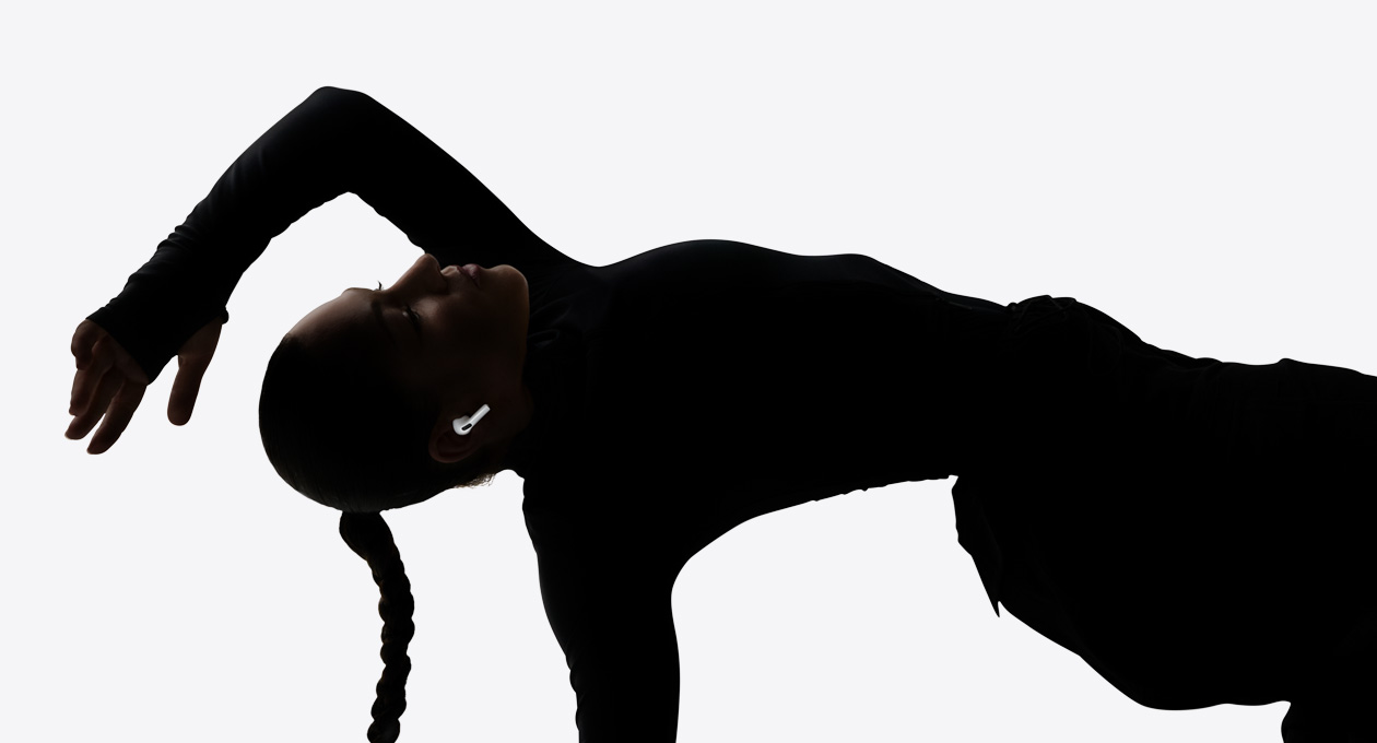 سماعات AirPods&nbsp;Pro&nbsp;3 موضوعة في أذن راقصة وهي تستمتع بتجربة استماع من دون استخدام يديها