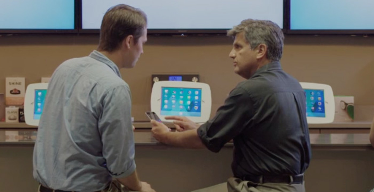 Hai người đàn ông đang ngồi tại O Bar, nhìn vào màn hình iPhone.