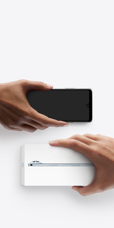 Mains échangeant des téléphones, téléphone Android sans coffret à gauche, nouvel iPhone Air dans son coffret à droite